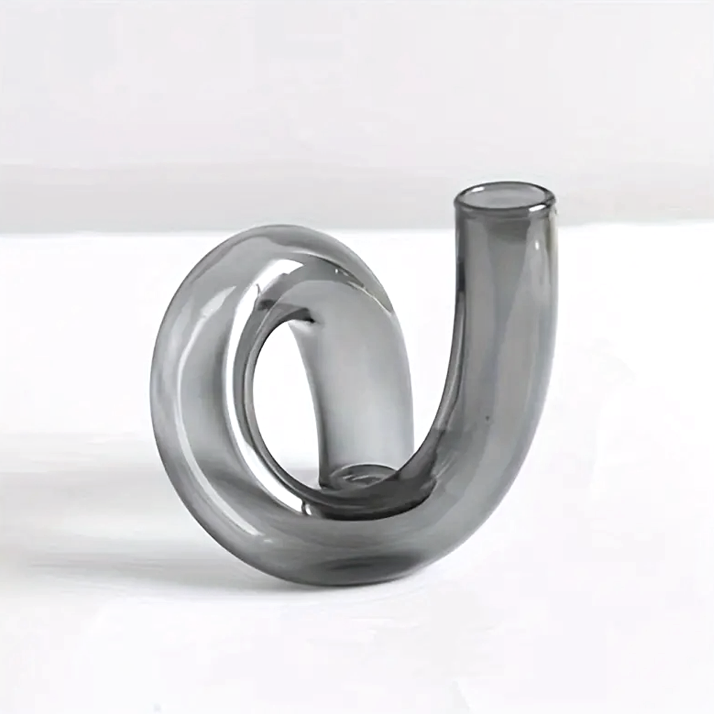 Smoke grey J-Curve vase on a pale surface, lit to show the tinted glass wall