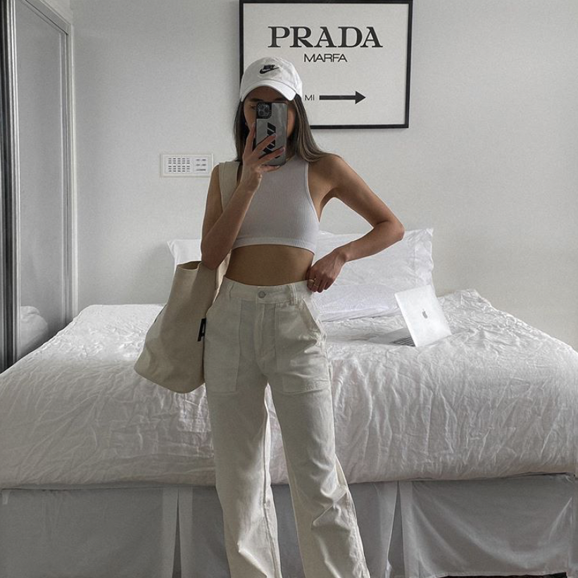 Woman taking a mirror selfie beneath the Prada Marfa print in a black frame
