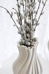 Faux pussy willow bundle with soft grey catkins styled in a sculptural neutral vase in a minimalist setting