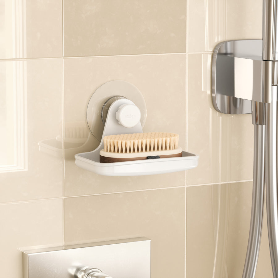 Umbra Flex adhesive soap dish in a tiled shower holding a nail brush