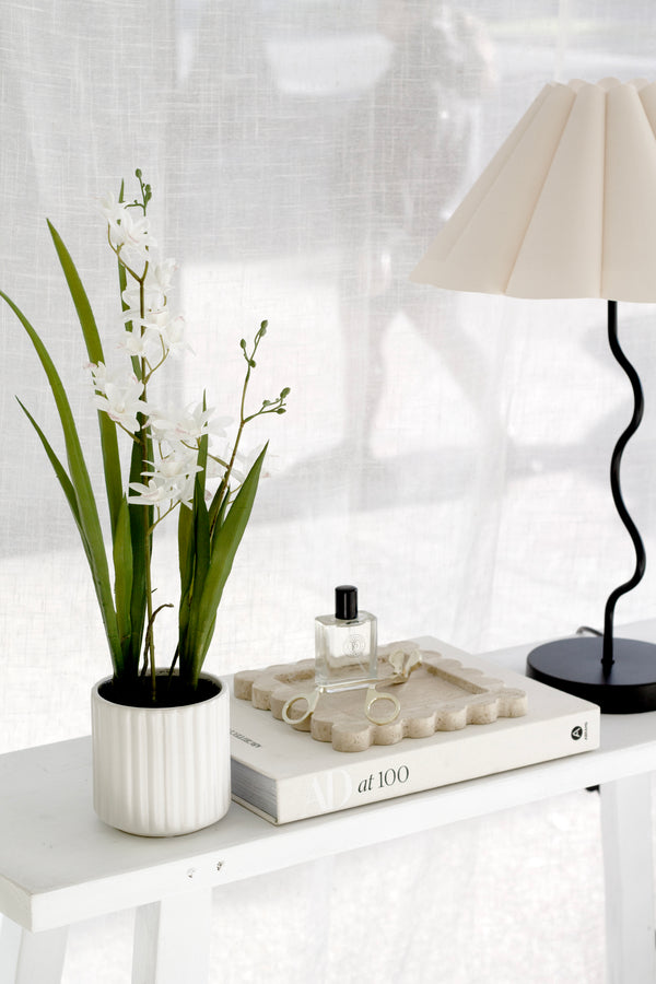 Artificial white cymbidium orchid in a sculptural ceramic pot styled on a console with books and decor – 55cm faux plant for timeless, elegant home interiors.