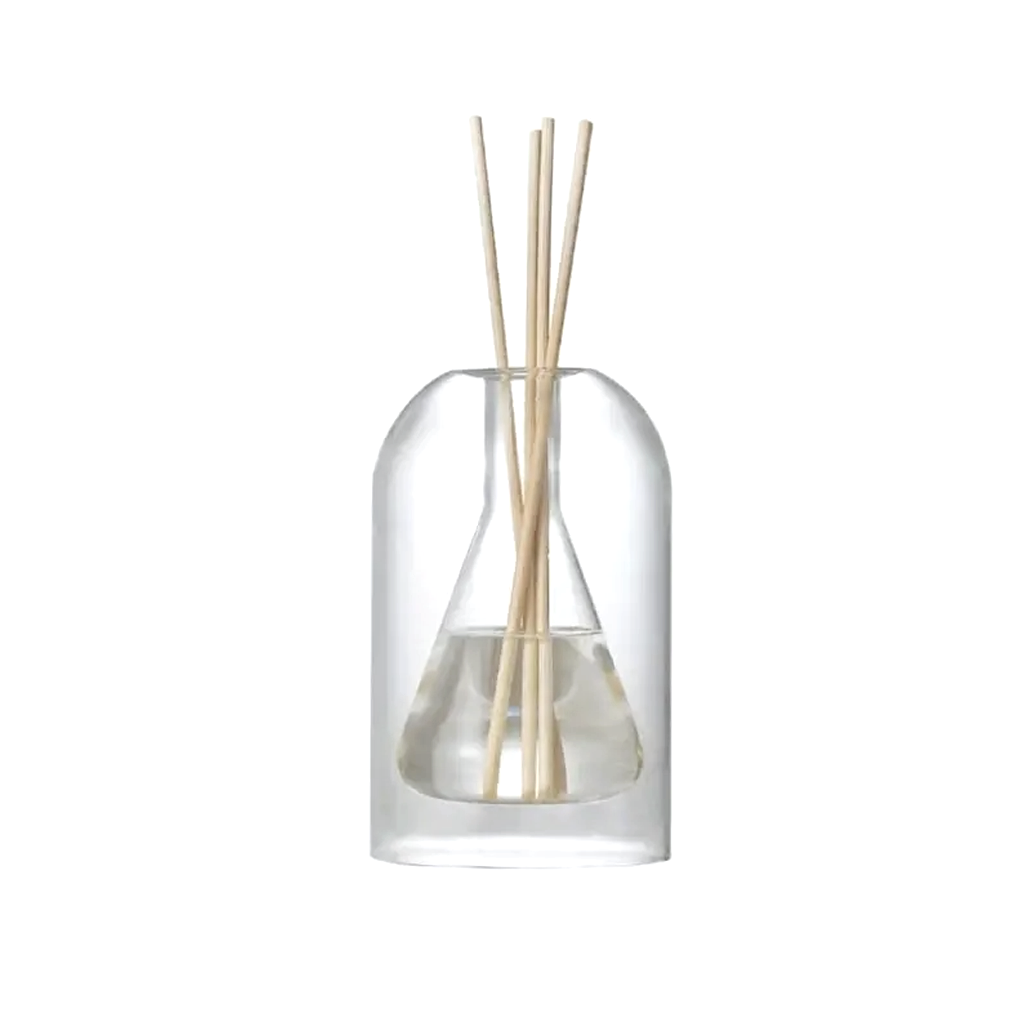 Glass reed diffuser with a cone shaped inner reservoir and natural reeds, on a plain background
