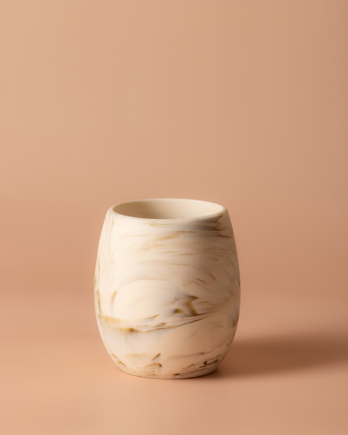 Tiramisu resin tumbler with cream and caramel marbling on a warm peach background