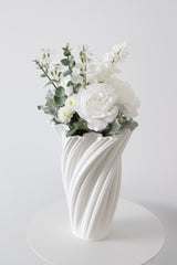 White rose and sweet pea artificial bouquet styled in sculptural white vase