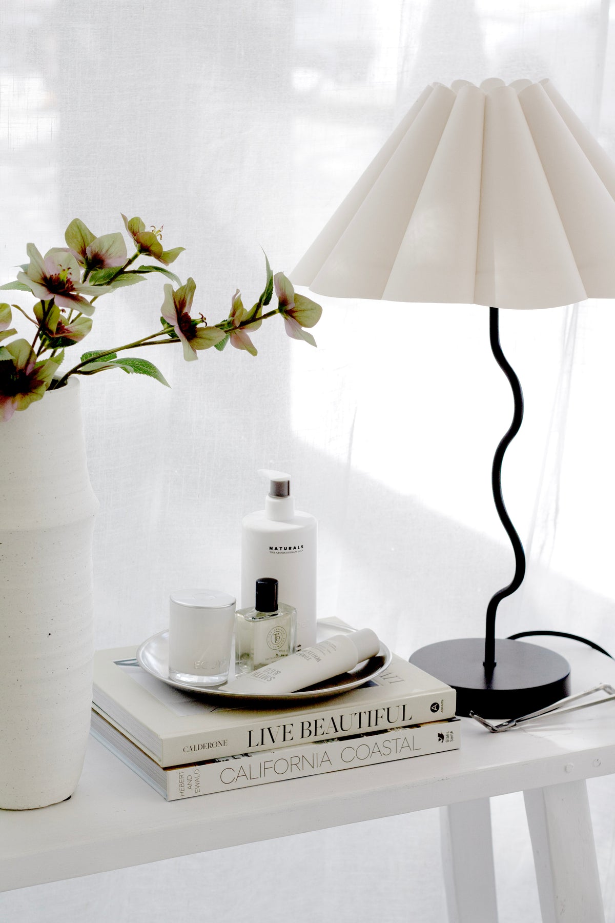 Round stainless steel decor tray styling candles and skincare on bedside table