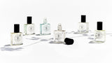 Five bottles of The Perfume Oil Collection Gift Set - Woody by The Perfume Oil Company on a white surface.