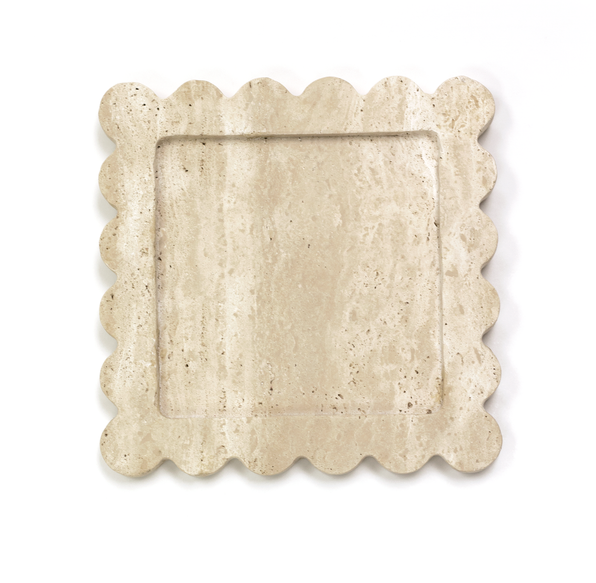 Scalloped travertine tray styled with perfume and accessories on a coffee table