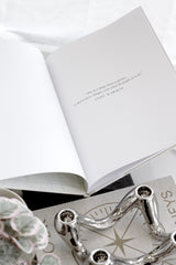 Open linen school photo archive journal with quote page styled on neutral surface