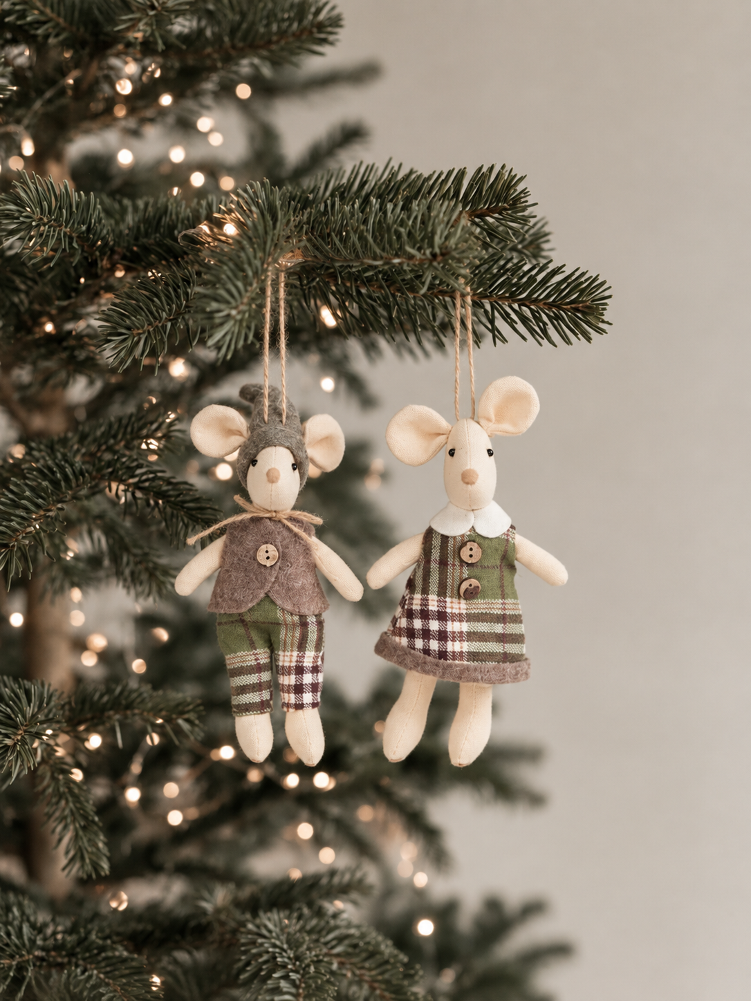 Mister and Miss Scott mouse decorations in green and taupe checks hanging side by side on a lit Christmas tree