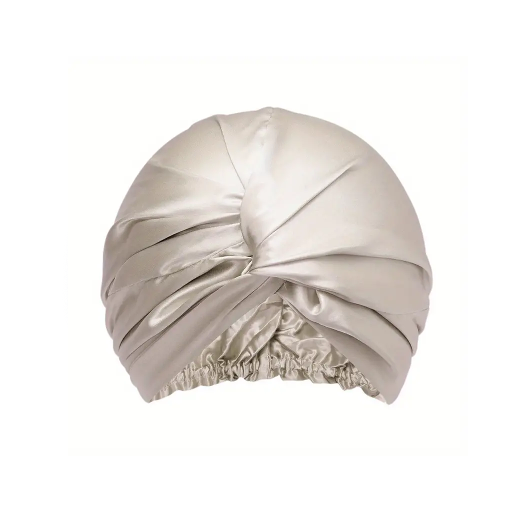 Mulberry silk sleep bonnet in champagne with a twisted front knot, on a plain background