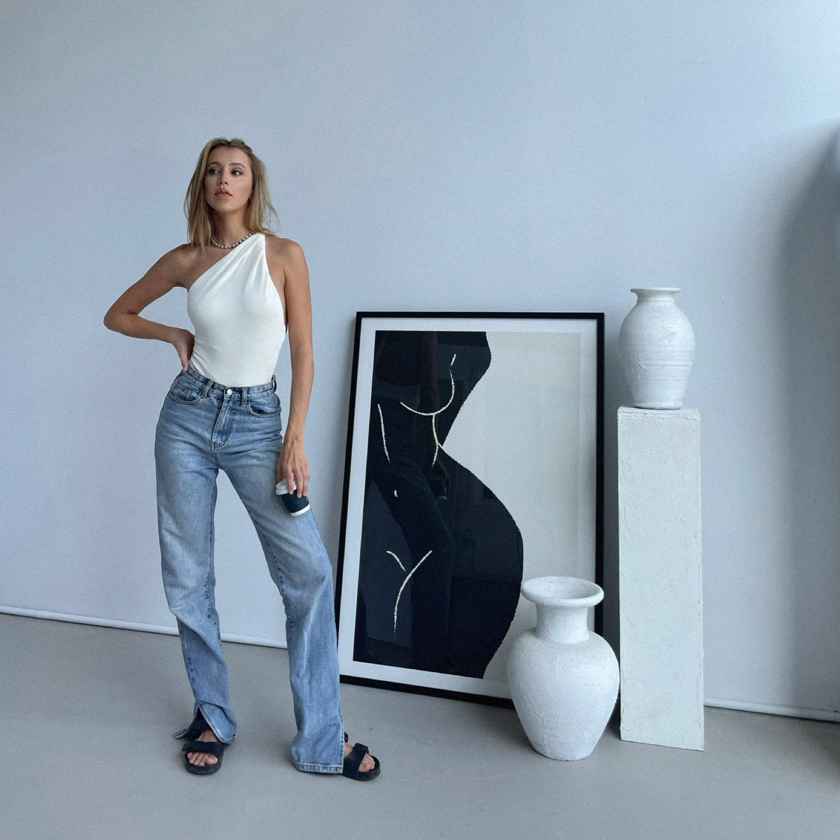 Sky Print No. 1 in black framed on the floor beside white vases and a plinth