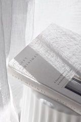 Soft Minimal book by Norm Architects styled on a white side table with natural light and linen curtains.