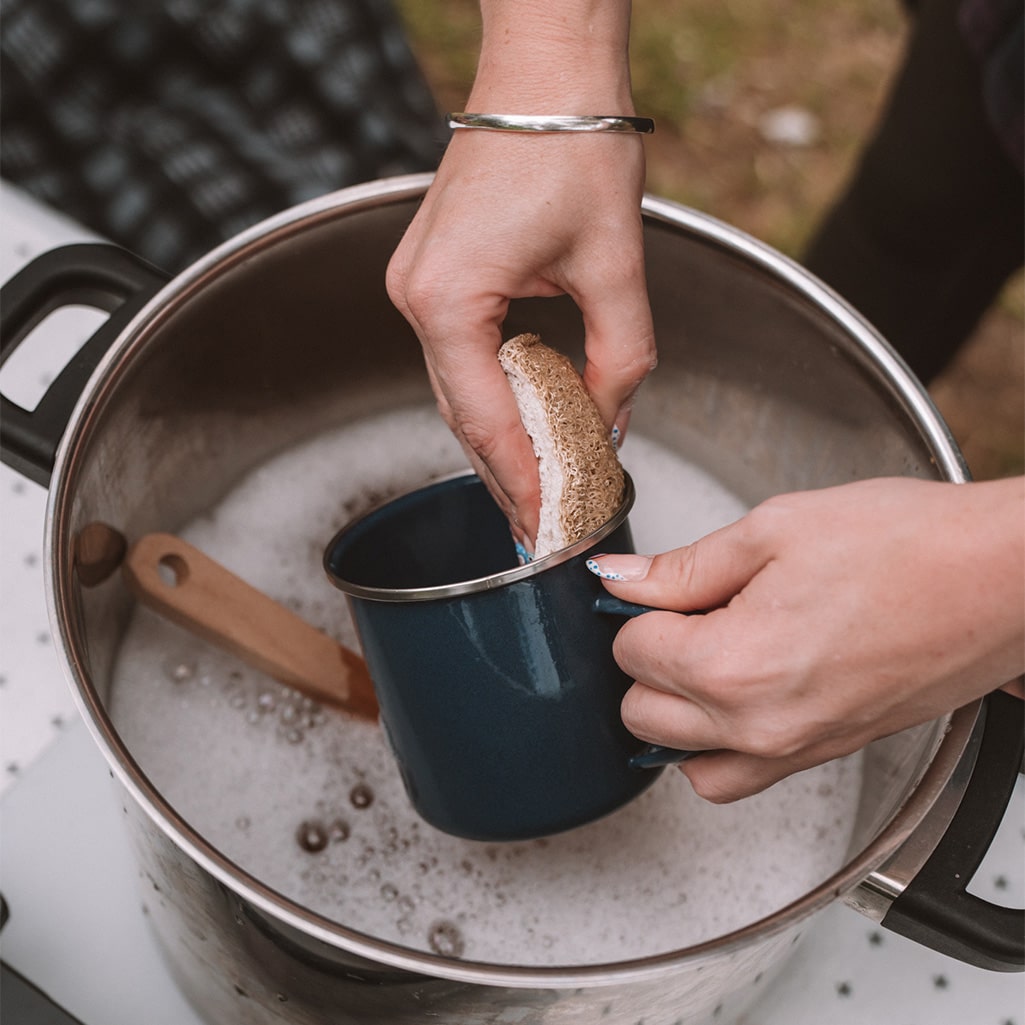 A person using the Good Change ECO SCRUBS 2-PACK, a natural option, to scrub a pot with a sponge.