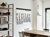 Oversized Stendig wall calendar hanging in a modern dining and kitchen space