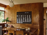 Stendig Calendar by Massimo Vignelli on a wood panelled wall in a warm interior