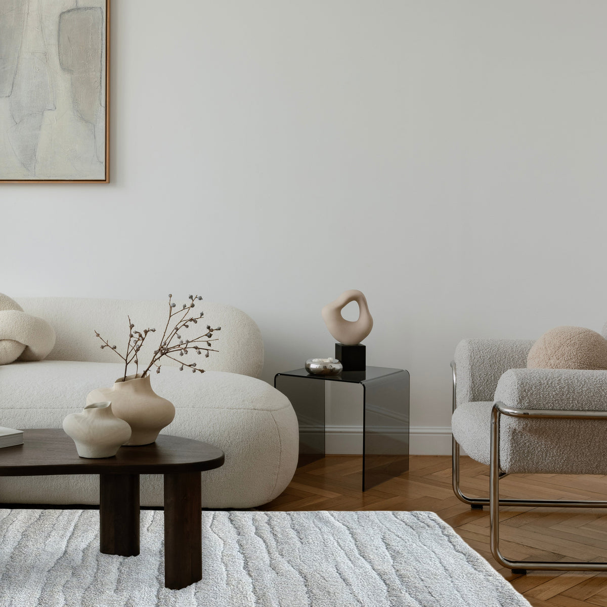 Drift grey rug in a pale living room with a cream curved sofa and low black coffee table