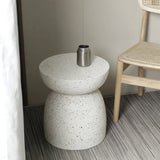 A Pedestal Side Table - Fleck White by Flux Home with a chair next to it.