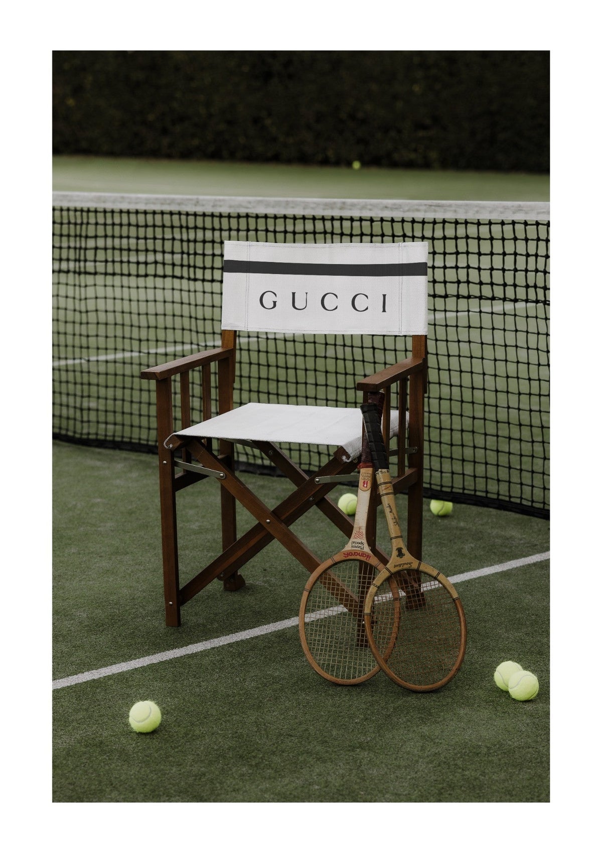 The Courtside Seat Print by Papier HQ, a courtside chair, wooden racquets and tennis balls on a deep green court