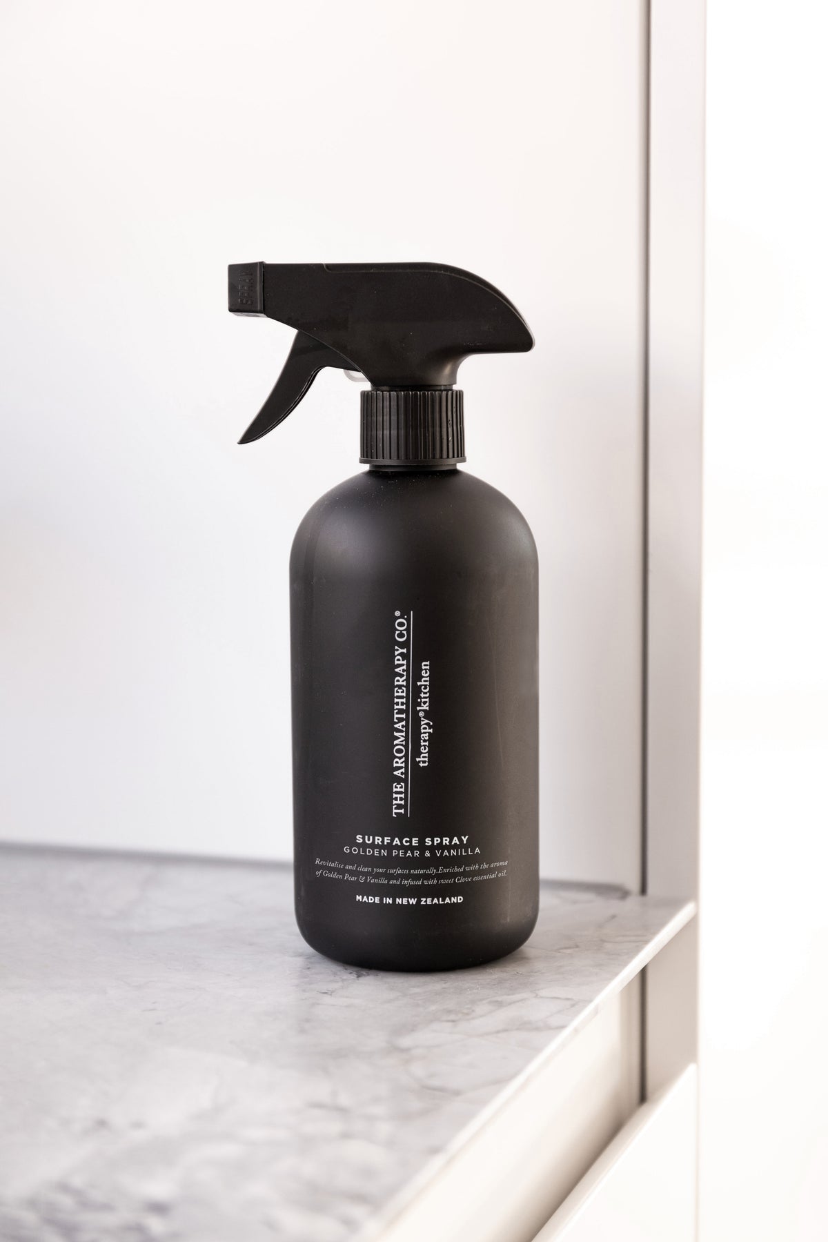 Black surface spray bottle on a marble ledge in front of a mirror