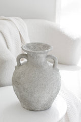Thira Vase styled beside a white armchair in a neutral-toned setting
