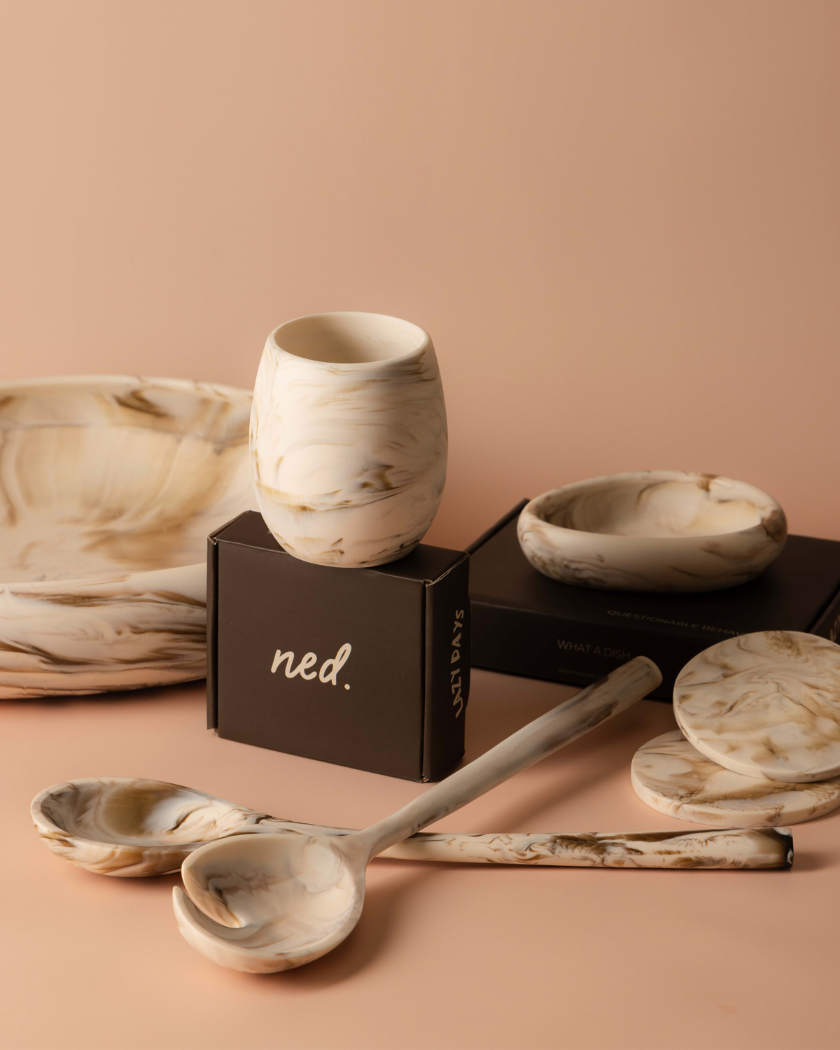 Tiramisu tumbler on a gift box with coasters, salad servers, a small bowl and a large bowl in cream resin
