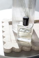 Tobacco Vanille inspired perfume oil in luxe glass rollerball bottle styled on travertine tray – vegan, cruelty-free fragrance.