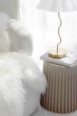 Ribbed polyurethane side table styled as bedside table with lamp and book