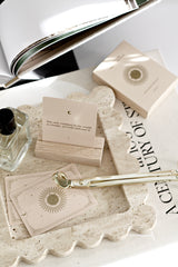 Close-up of travertine scalloped tray styled with cards, perfume, and accessories on a coffee table, showcasing natural stone texture and wavy edges.