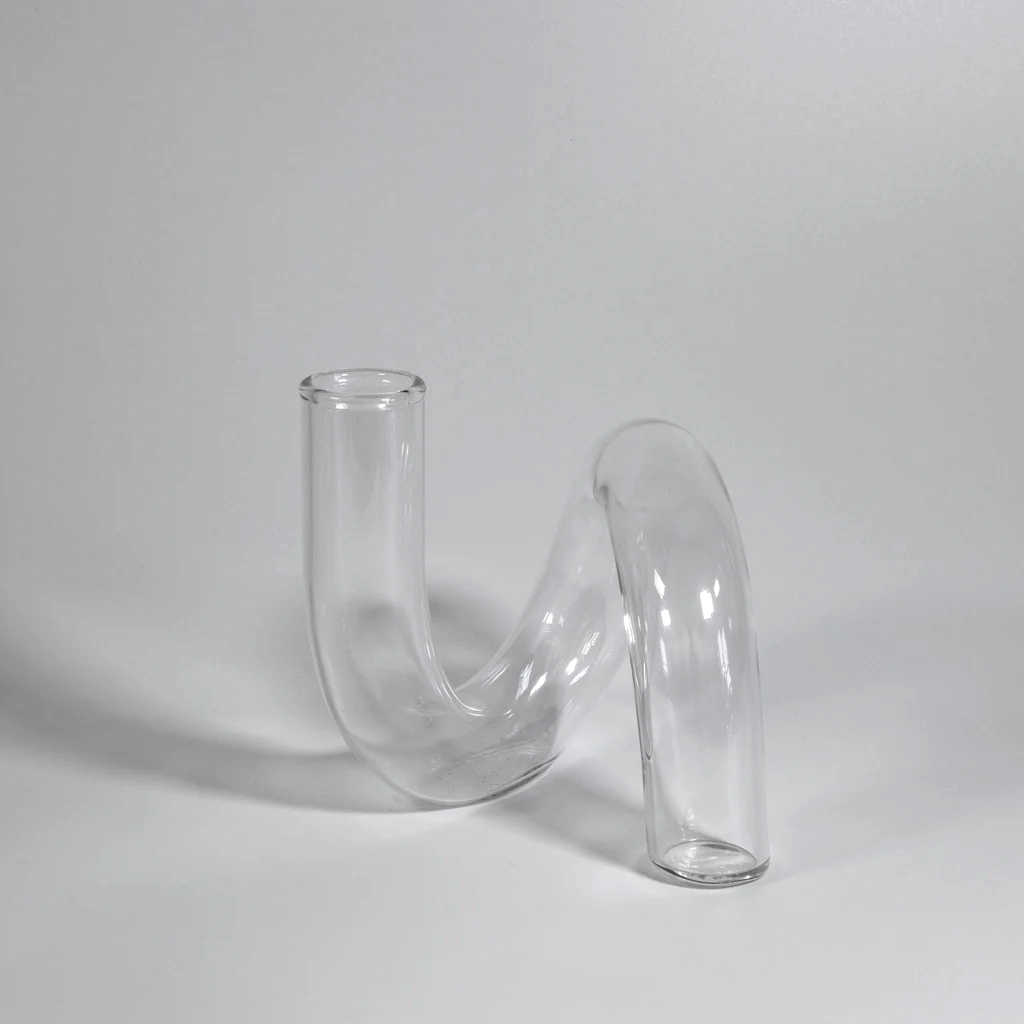 Clear J-Curve vase photographed from behind against a grey backdrop