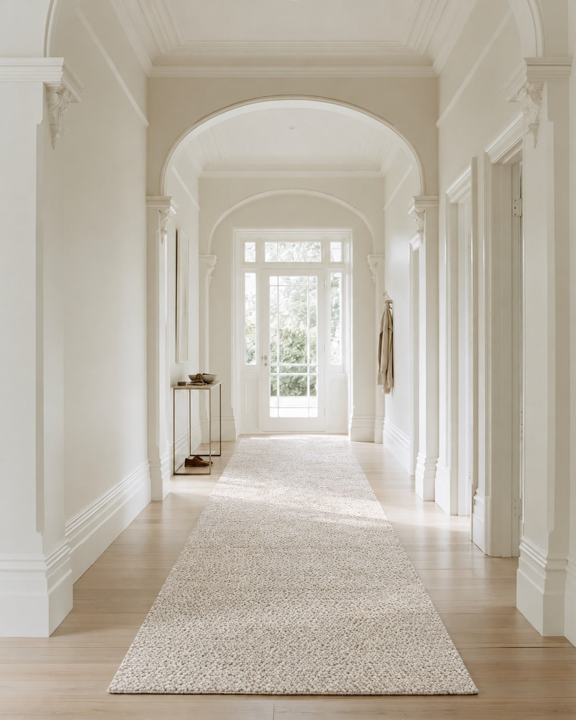 Tundra Pebble Beige Rug in the runner size along a white villa hallway with arches and timber floors