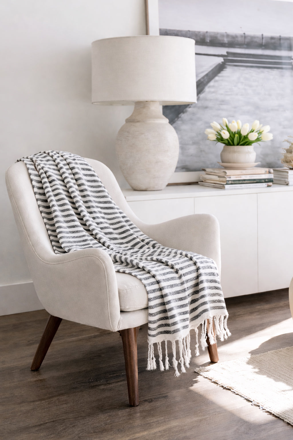 Grey striped Turkish towel draped over a cream armchair in a bright living room