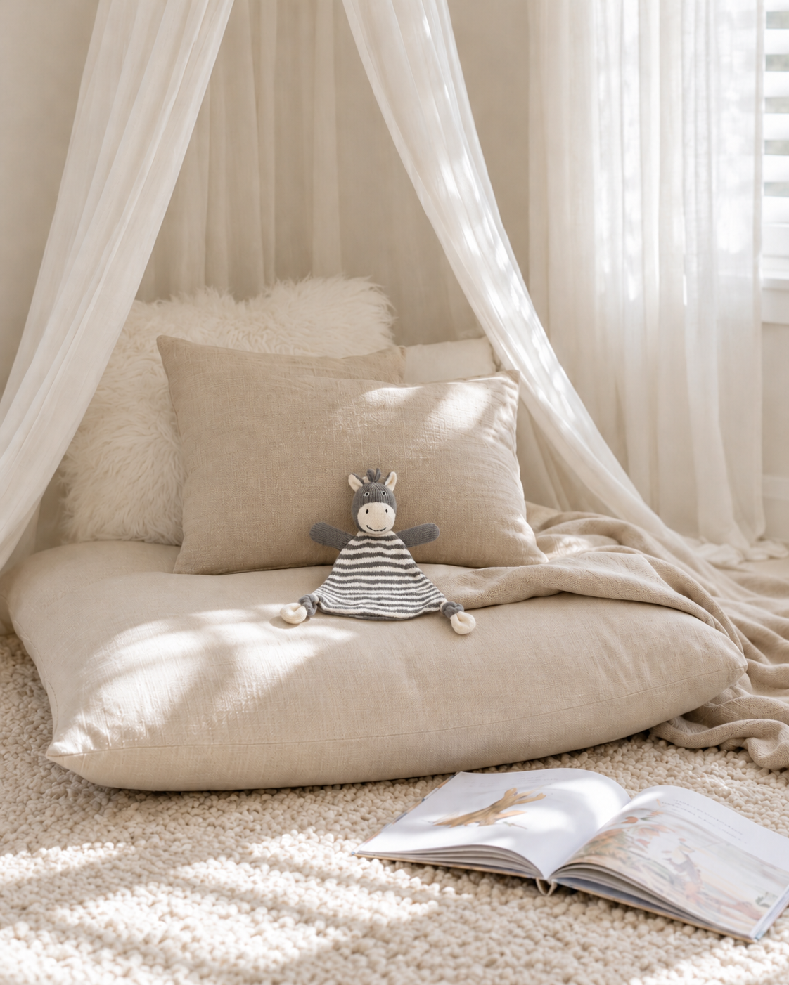 Bowie the zebra knitted comforter on a linen floor cushion in a canopy reading nook