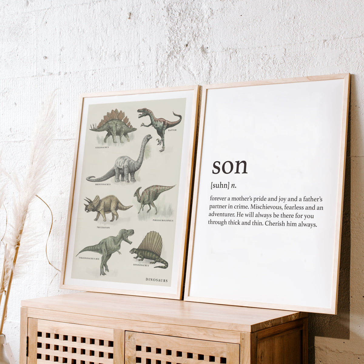 Vintage Dino print in a natural frame leaning beside a Papier HQ Son print on a rattan cabinet