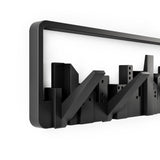 A black frame with a Skyline Wall Mounted Hook - perfect wall art for small spaces, by Umbra.