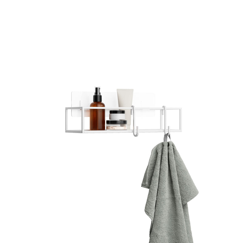 An Umbra adhesive-installed Cubiko Shower Bins, Set Of 2, bathroom shelf with a towel hanging on it, featuring a bent wire design.