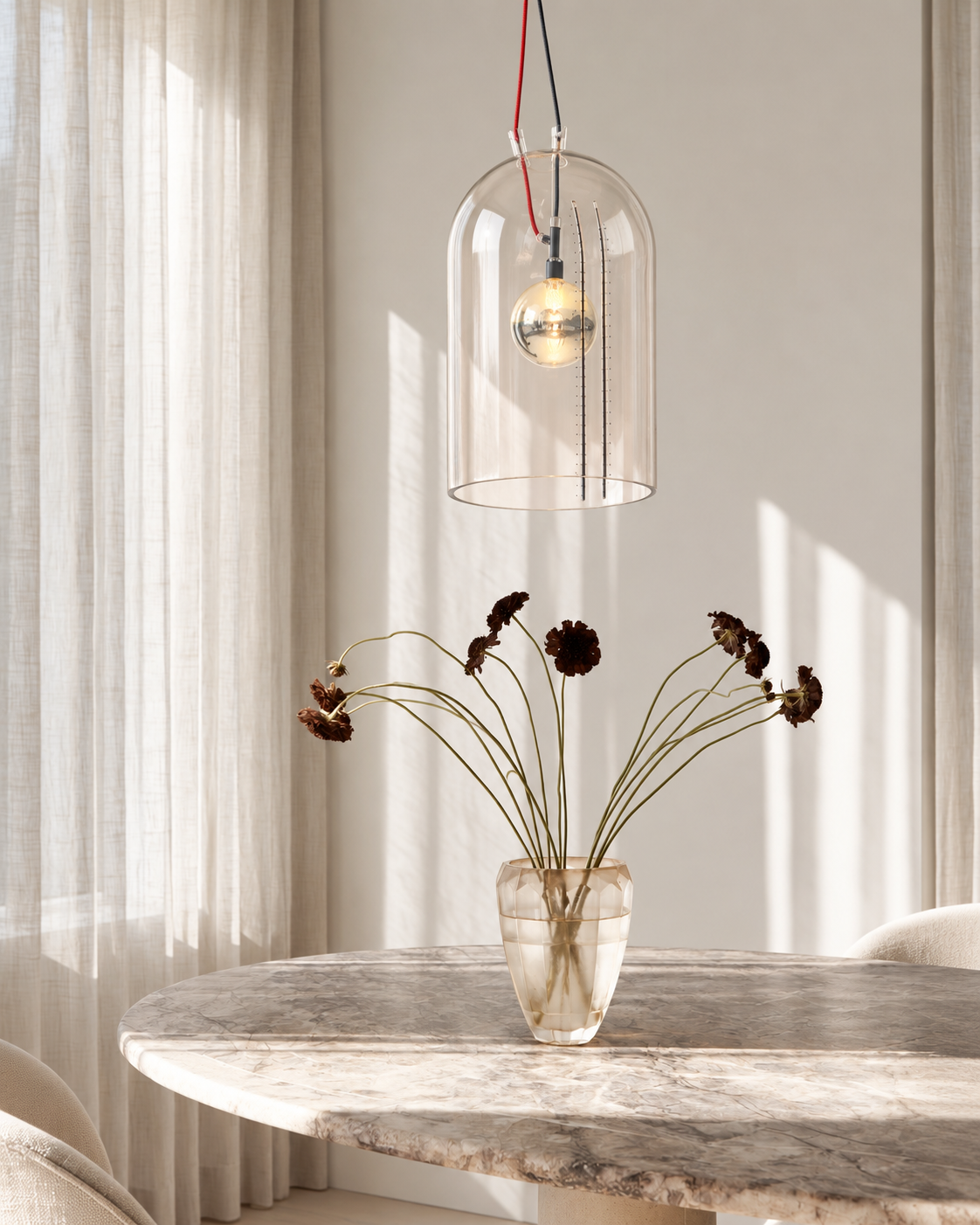 Milk Jar glass pendant with red cord hanging over a round marble table in a sunlit dining nook