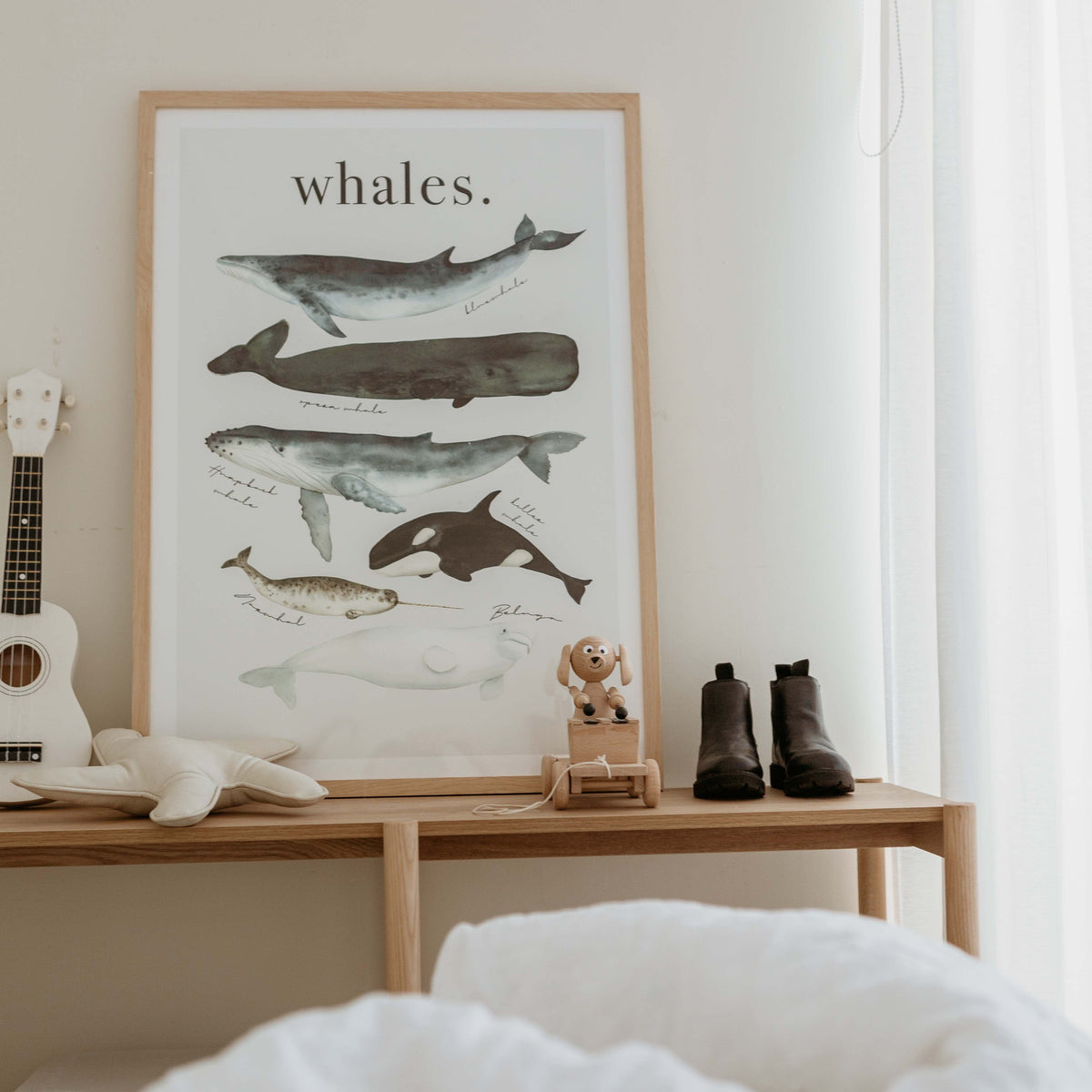 Watercolour Whales print in a natural frame on a timber bench with small leather boots