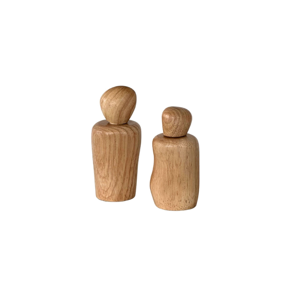 Wavy salt and pepper shakers in natural wood on a dining table