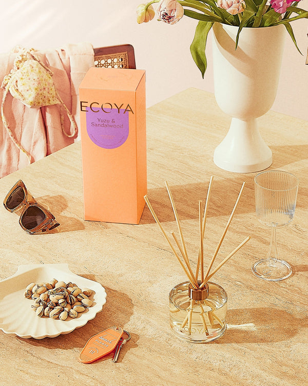 A beautiful arrangement of flowers and Ecoya: Sensory Escapes: Yuzu & Sandalwood Reed Diffusers, enhancing the home design with delightful fragrances.