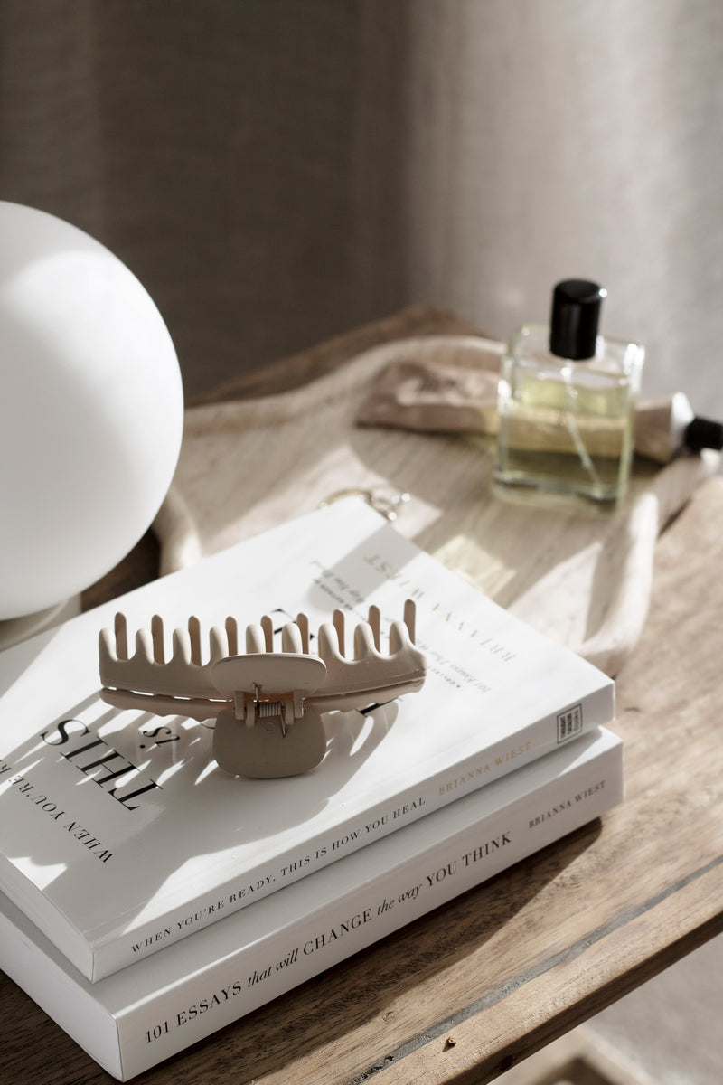 When You’re Ready, This Is How You Heal by Brianna Wiest styled on a wooden table with perfume and a lamp.