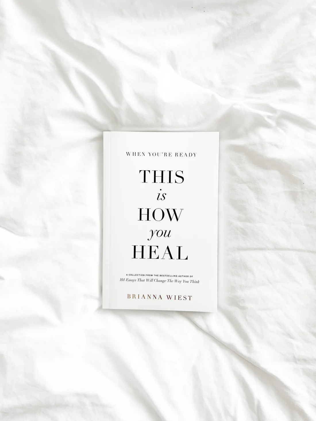 Brianna Wiest book When You’re Ready, This Is How You Heal styled on white linen bedding; self-growth and healing guide.