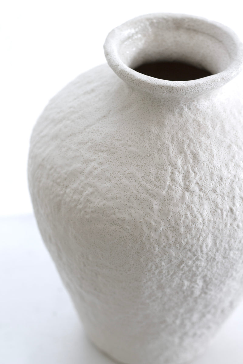 Sculptural white vase with rough stone texture viewed from above