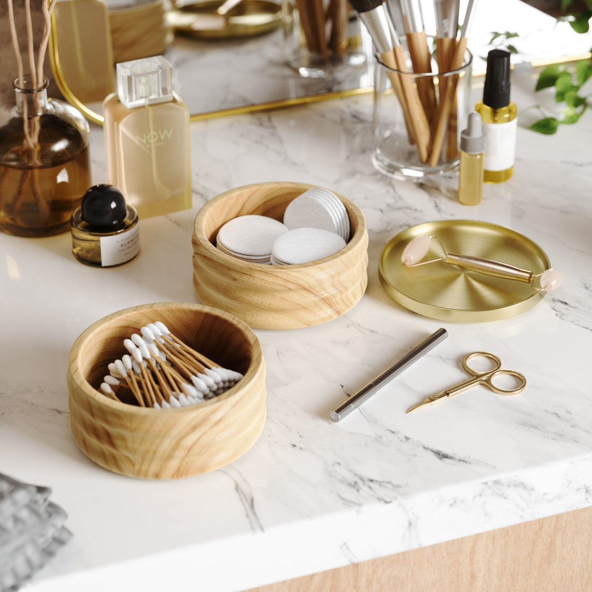 Umbra Tesora storage box open on a marble vanity, holding cotton buds and pads