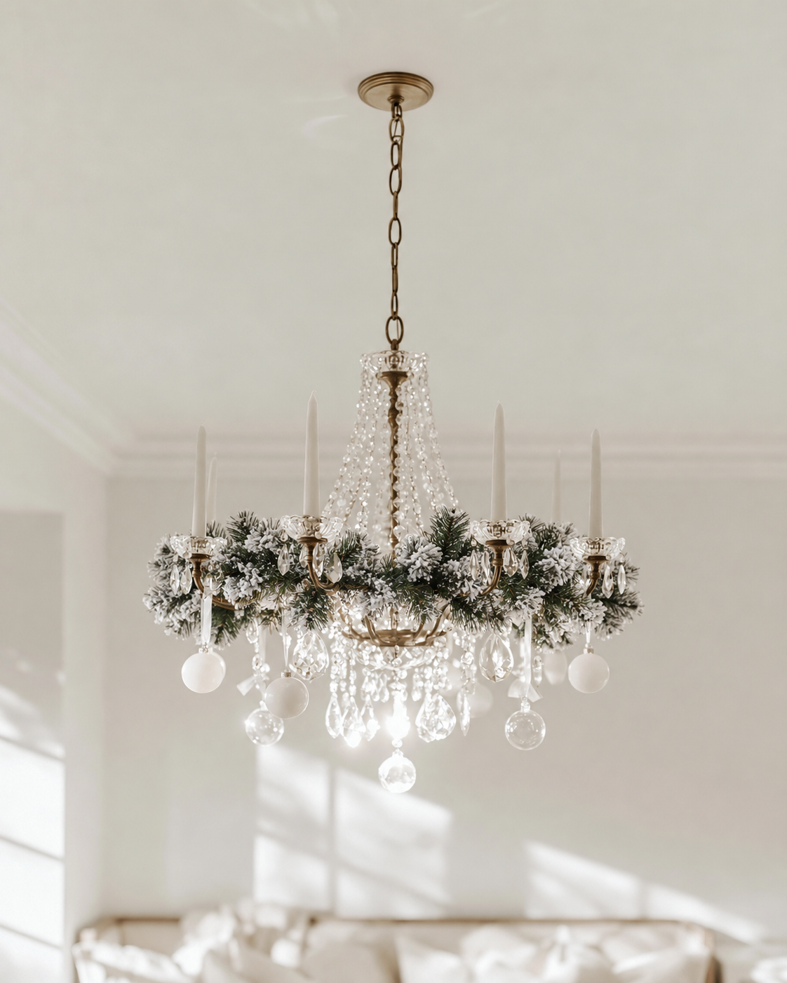 Royale Flocked Christmas Garland wound around a crystal chandelier with white candles and baubles