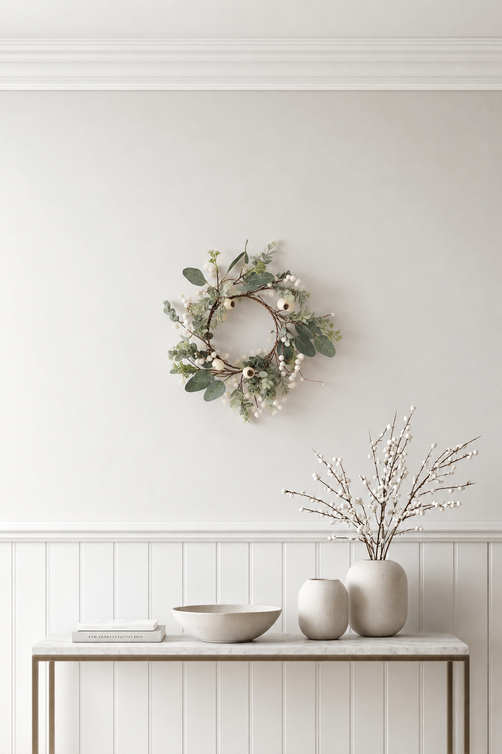 Podberry Wreath in cream and sage hanging on a white wall above a console with vases of blossom branches