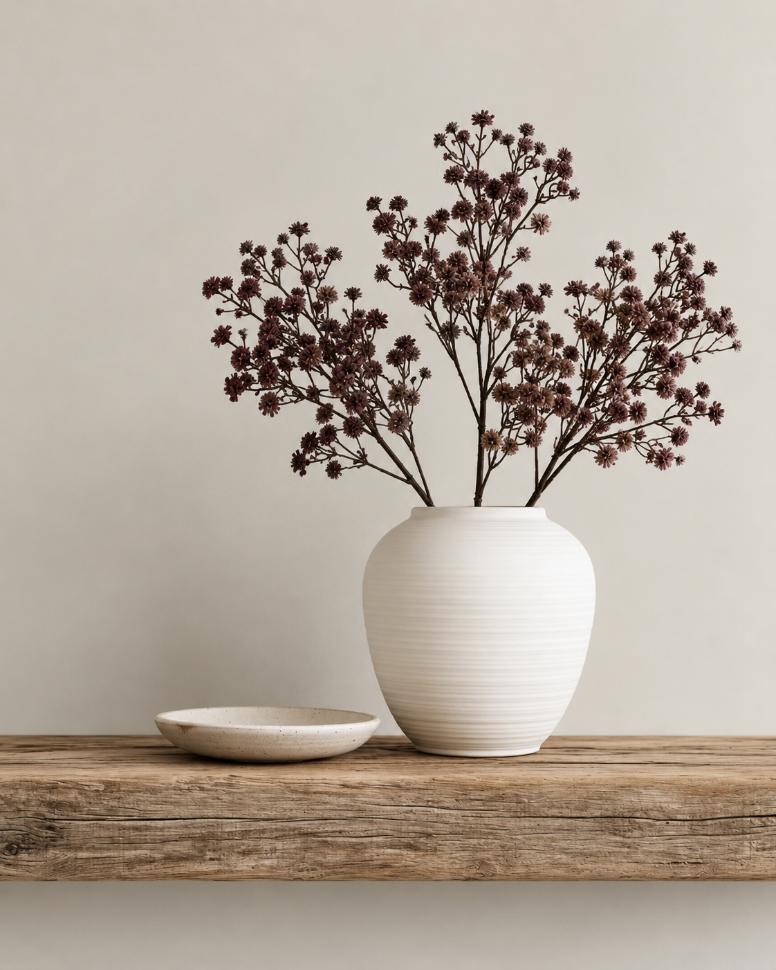 Shiraz faux gypsophila stems in a white ribbed vase on a rustic timber shelf