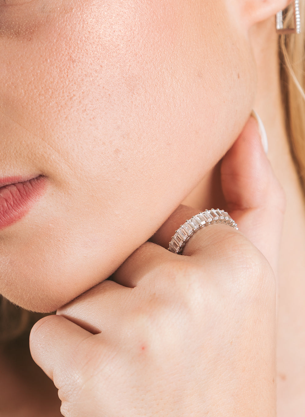 Your Baguette Ring worn on a finger resting against the jaw, close crop