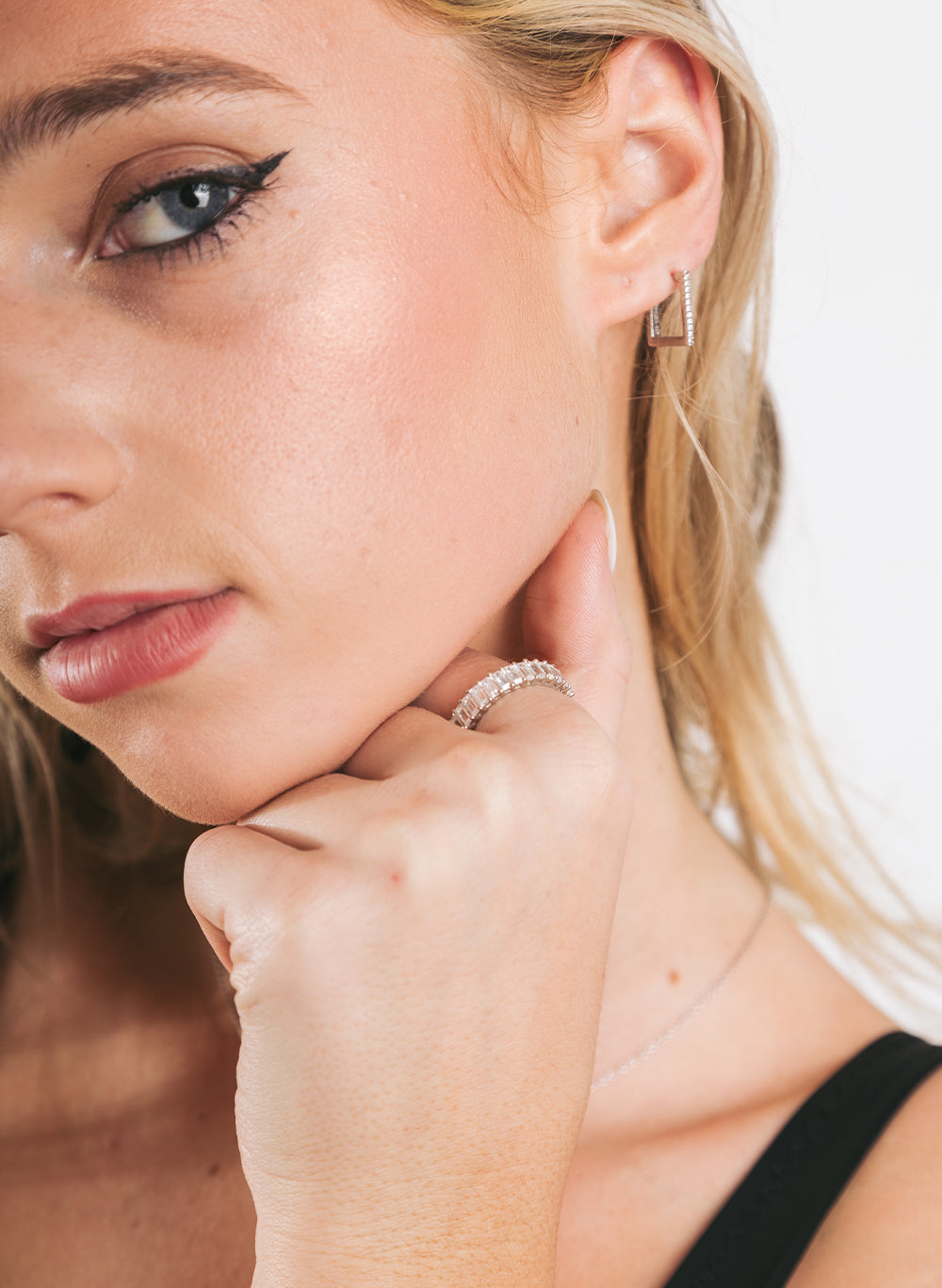 Model with hand under her chin wearing the baguette eternity band