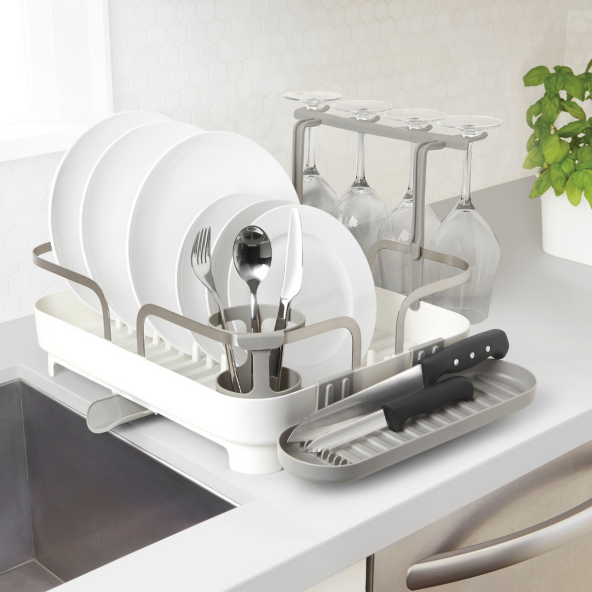 Holster dish rack on a kitchen bench beside the sink, loaded with plates and glasses