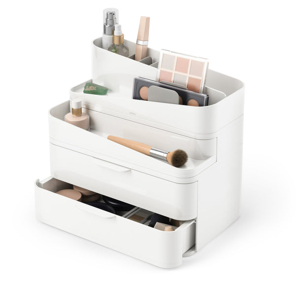 An Umbra Glam Cosmetic Organizer Large showcasing a beauty station setup with an assortment of makeup and skincare products neatly arranged within.